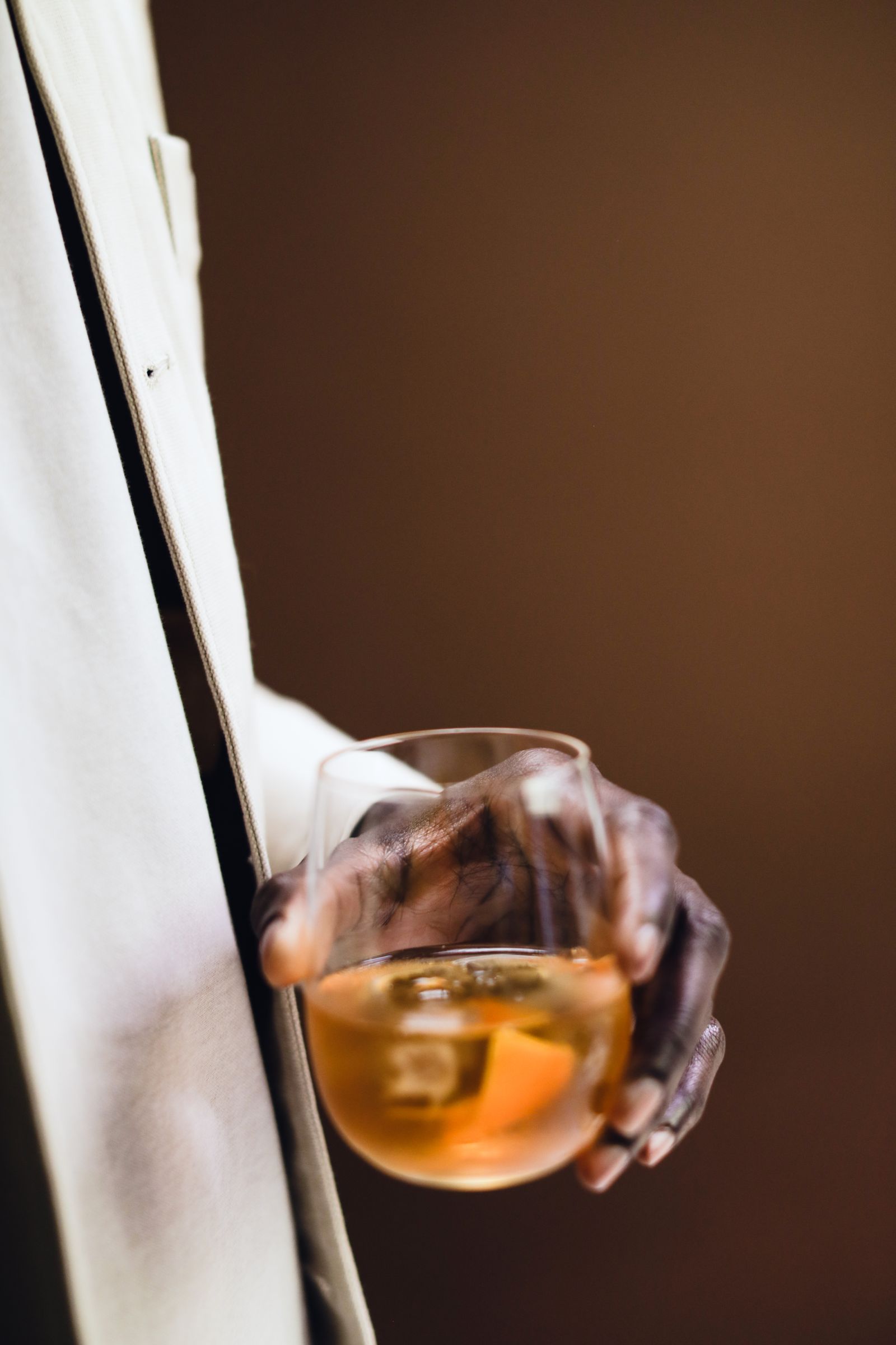 A hand holding a distinctive whisky glass
